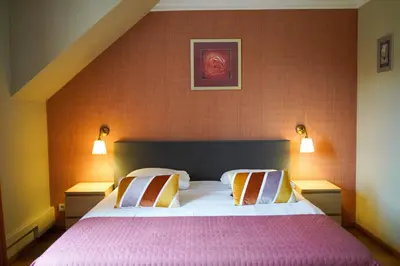 a bedroom with a large bed with two pillows at Hotel Prins van Oranje in Diest