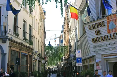 a city street with people walking down the street at ALMA Grand Place Hotel in Brussels