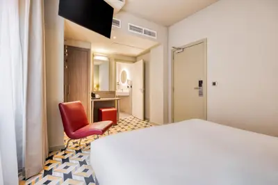 a hotel room with a bed and a chair at ALMA Grand Place Hotel in Brussels