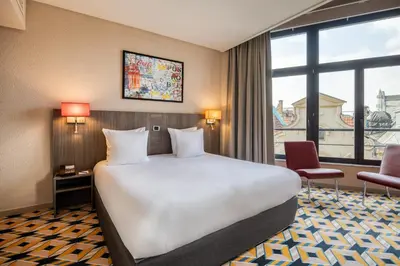 a hotel room with a bed and a large window at ALMA Grand Place Hotel in Brussels