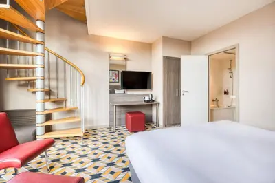 a hotel room with a bed and a staircase at ALMA Grand Place Hotel in Brussels