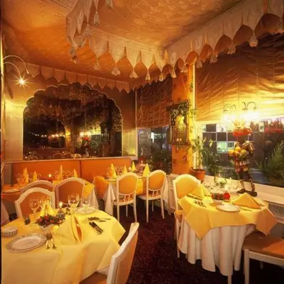 a restaurant with tables and chairs with yellow table cloth at Hotel L'auberge Du Souverain in Brussels