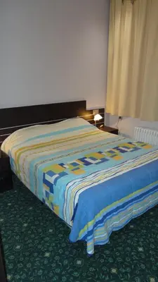 a bedroom with a bed with a colorful blanket at Hotel L'auberge Du Souverain in Brussels