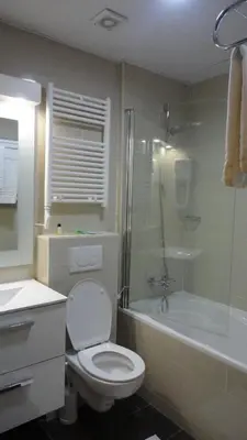 a bathroom with a toilet and a tub and a sink at Hotel L'auberge Du Souverain in Brussels