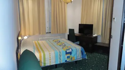 a hotel room with a bed and a television at Hotel L'auberge Du Souverain in Brussels