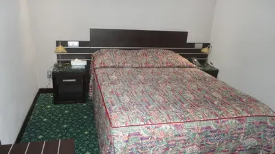 a bedroom with a bed and a nightstand with a bed sidx sidx sidx sidx at Hotel L'auberge Du Souverain in Brussels