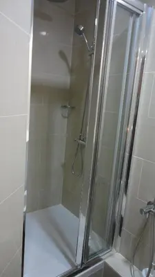 a bathroom with a shower with a glass door at Hotel L'auberge Du Souverain in Brussels
