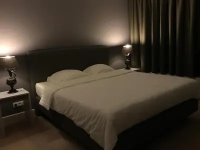 a bedroom with a large white bed with two lamps at B&B Garden55 in Mechelen