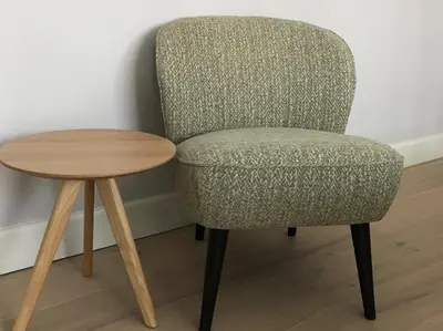 a gray chair next to a wooden table at B&B Garden55 in Mechelen