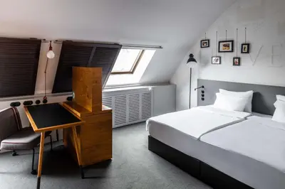 a bedroom with a bed and a desk in it at pentahotel Leuven in Leuven