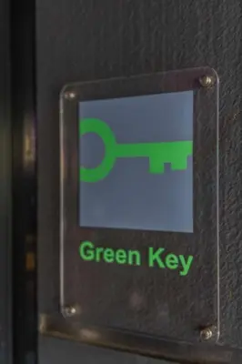 a green key sign on the side of a door at pentahotel Leuven in Leuven