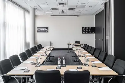 a conference room with long tables and chairs at pentahotel Leuven in Leuven