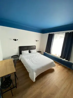 a bedroom with a white bed and a blue ceiling at Hotel Windsor in Brussels
