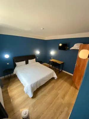 a bedroom with a white bed and a blue wall at Hotel Windsor in Brussels
