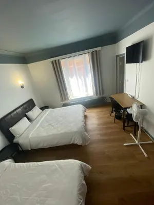 a hotel room with two beds and a table at Hotel Windsor in Brussels