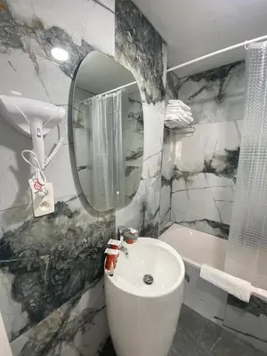 a bathroom with a sink and a mirror and a tub at Hotel Windsor in Brussels