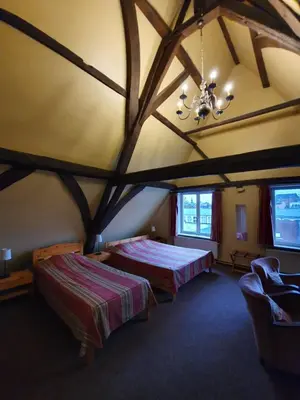 a large room with two beds and a chandelier at Erasmus Hotel in Ghent