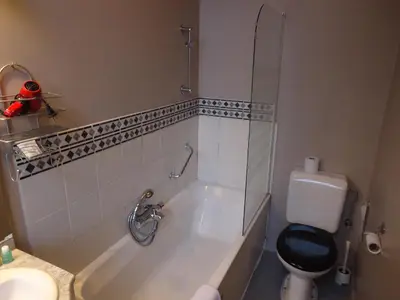 a bathroom with a tub and a toilet and a sink at Erasmus Hotel in Ghent