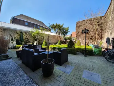 a patio with couches and a table and chairs at Erasmus Hotel in Ghent