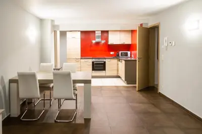 a kitchen and dining room with a table and chairs at Wellness Apart Hotel in Brussels