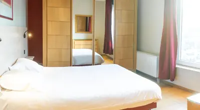 a bedroom with two beds and a mirror at Wellness Apart Hotel in Brussels