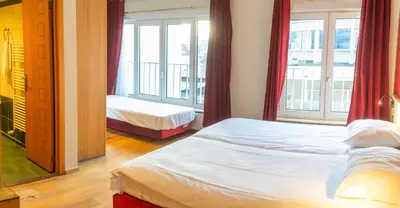 a bedroom with two beds and a large window at Wellness Apart Hotel in Brussels