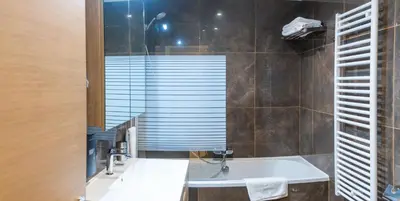 a bathroom with a tub and a sink and a window at Wellness Apart Hotel in Brussels