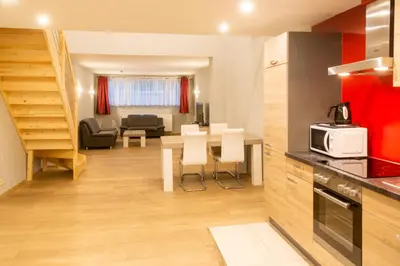 a kitchen and living room with a table and chairs at Wellness Apart Hotel in Brussels