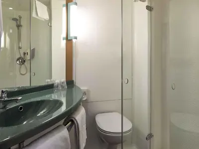 a bathroom with a sink and a toilet and a mirror at ibis Aalst in Aalst