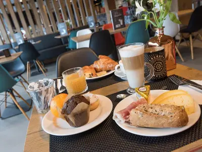 a table with two plates of food and two glasses of milk at ibis Aalst in Aalst