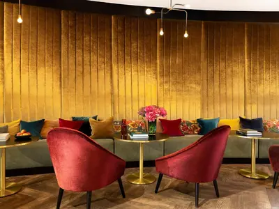 a dining room with red chairs and a table with pillows at Numa Brussels Royal Galleries in Brussels