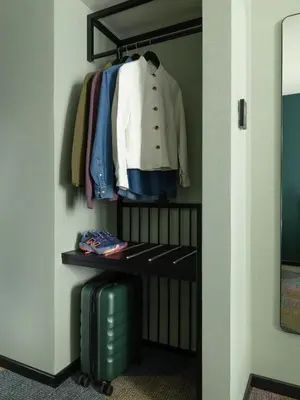 a closet with a suitcase and clothes on a rack at Numa Brussels Royal Galleries in Brussels