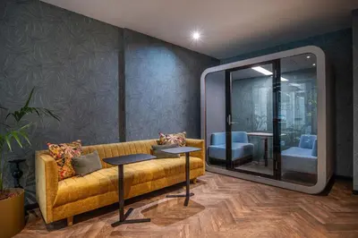 a living room with a yellow couch and a mirror at Numa Brussels Royal Galleries in Brussels