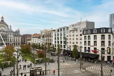 a city with people walking around a street with buildings at Hotel Indigo Antwerp City Centre by IHG in Antwerp