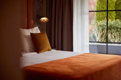a bedroom with a bed and a window at Van der Valk Hotel Dennenhof in Brasschaat