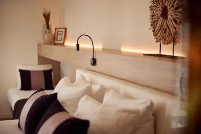 a bedroom with a bed with white and black pillows at Van der Valk Hotel Dennenhof in Brasschaat