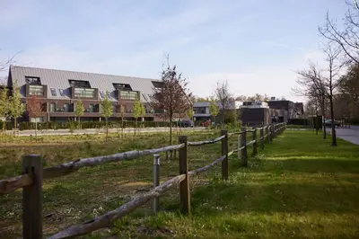 a fence in a field next to a building at Van der Valk Hotel Dennenhof in Brasschaat