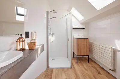 a white bathroom with a shower and a sink at Van der Valk Hotel Dennenhof in Brasschaat