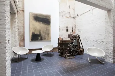 a room with chairs and a table and a painting at Hotel Vé in Mechelen