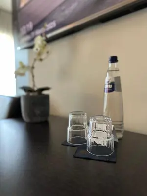 a table with two glasses and a bottle on it at Hotel Vé in Mechelen