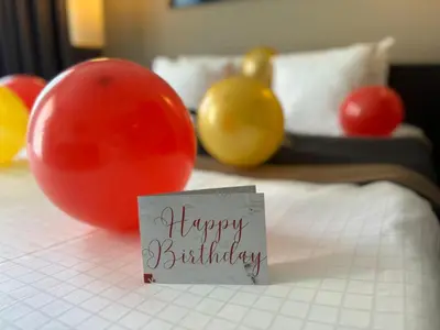 a happy birthday sign sitting on top of a bed at Hotel Vé in Mechelen