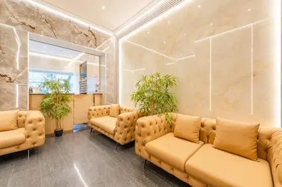 a waiting room with brown leather couches and potted plants at Hotel Barry in Brussels