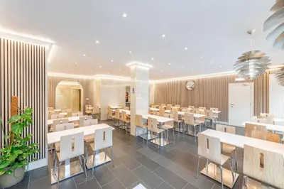 a restaurant with tables and chairs in a room at Hotel Barry in Brussels