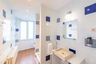 a white bathroom with a sink and a window at Hotel Barry in Brussels