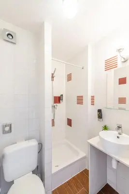 a white bathroom with a toilet and a sink at Hotel Barry in Brussels