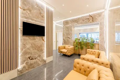 a living room with two chairs and a flat screen tv at Hotel Barry in Brussels