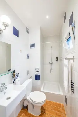 a white bathroom with a toilet and a bath tub at Hotel Barry in Brussels