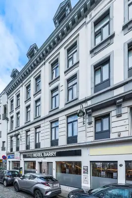 a large white building with cars parked in front of it at Hotel Barry in Brussels
