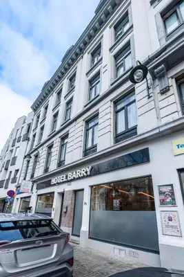 a store front of a building with a sign for a hotel battery at Hotel Barry in Brussels