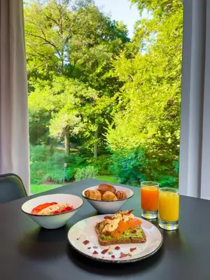 a table with two plates of food and two glasses of orange juice at Hotel Dolce La Hulpe Brussels in La Hulpe